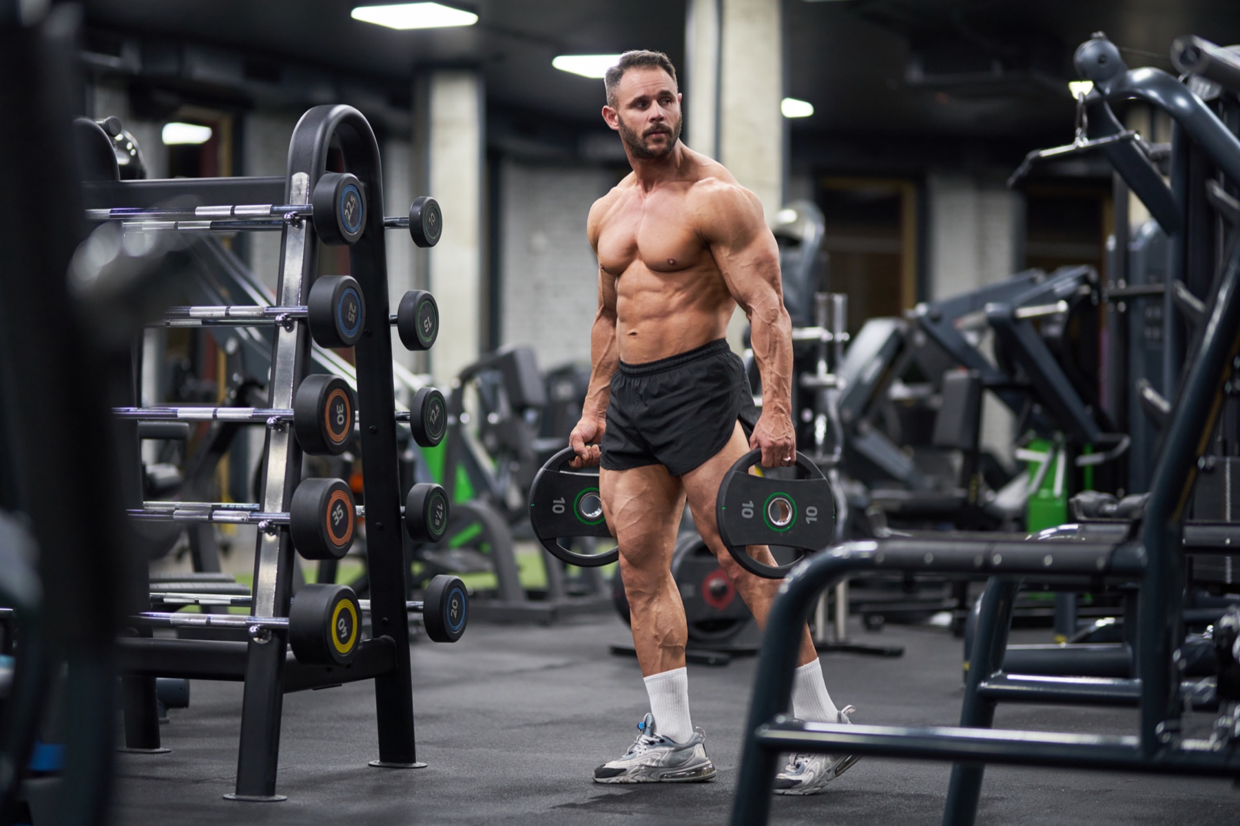 A member training on the floor of a modern gym